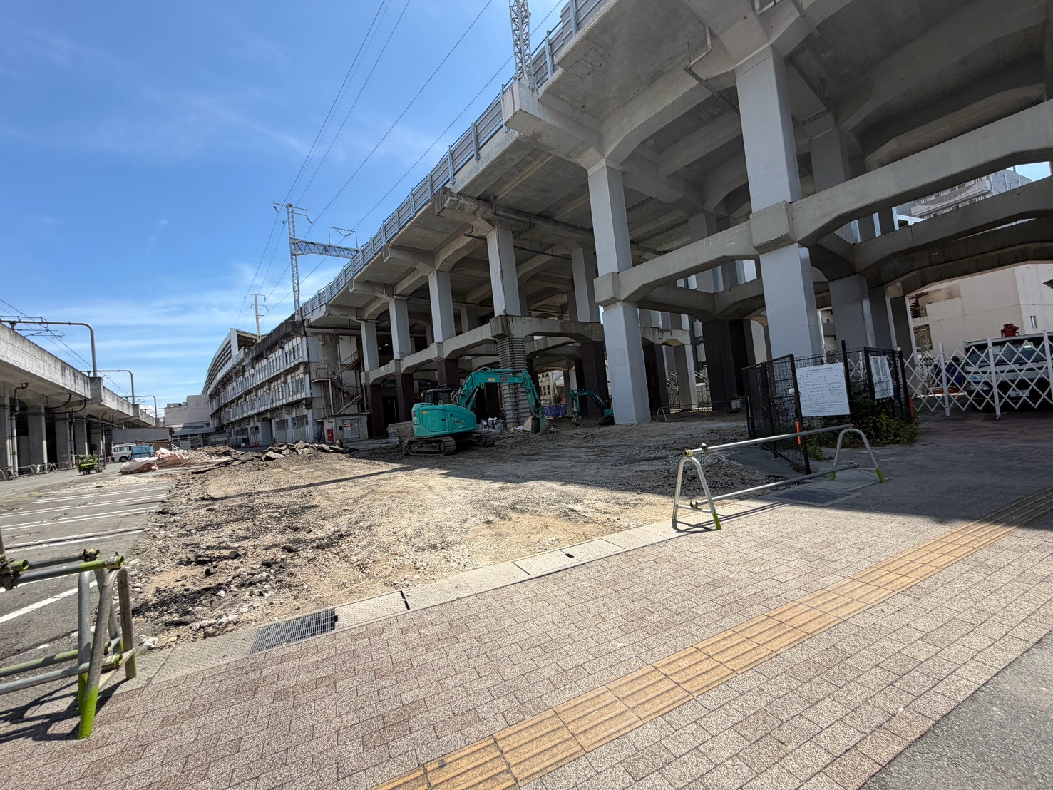 更地の奥にショベルカーが入っている様子