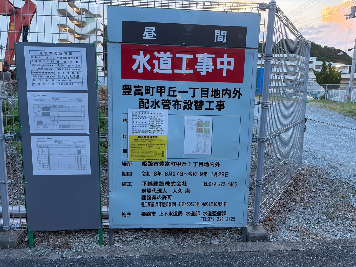 「昼間 水道工事中 豊富町甲丘一丁目地内外 配水管布設替工事」と書かれた看板