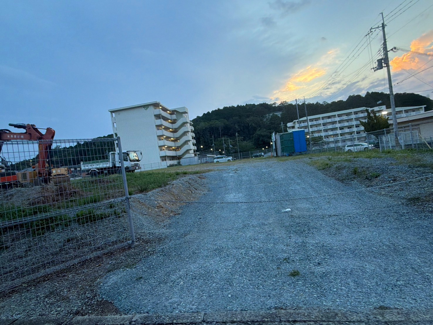 フェンス沿いに並んだ工事看板と、奥に見える重機