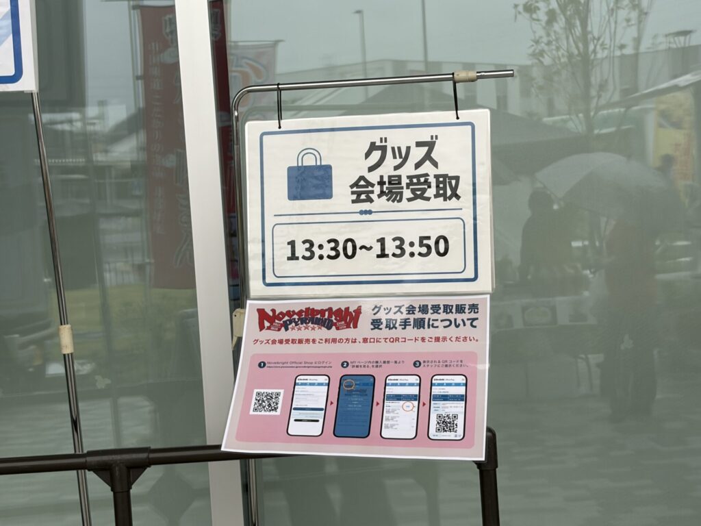 グッズ受取の列を案内するスタッフ