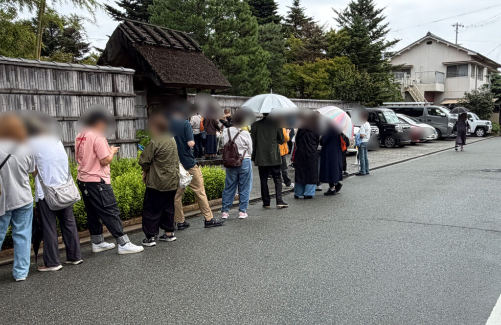 店舗の門の手前まで続く傘の列