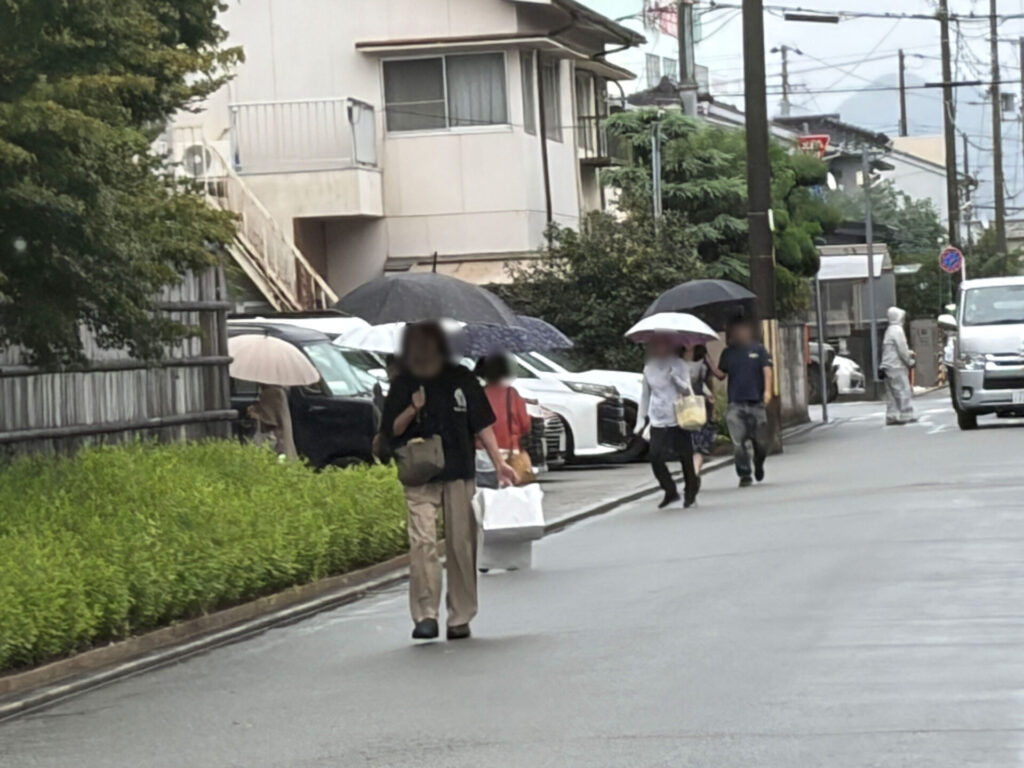 買い物を終えて白い袋を持って出てくる人