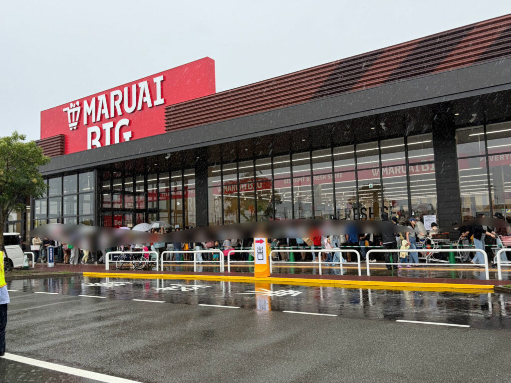 傘をさして並ぶマルアイBIGアクロスプラザ高砂店の来店客