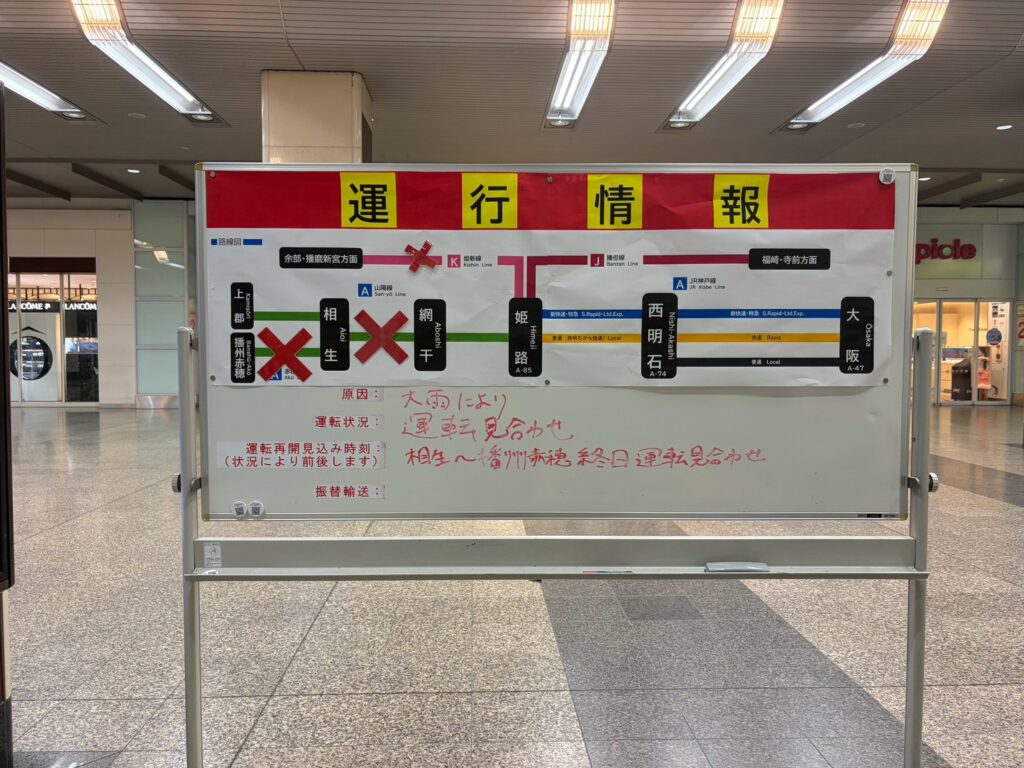 JR姫路駅の運行情報板。大雨により運転見合わせと手書きされている