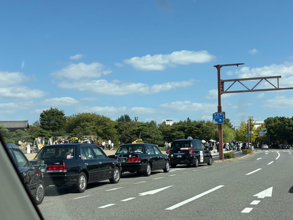 連休中の姫路城前の道路を走る車
