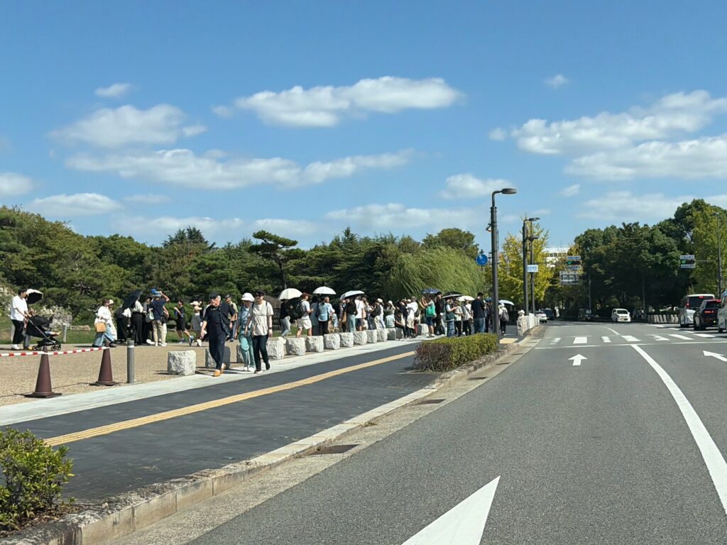 日傘を差した観光客で埋まる姫路城前の歩道