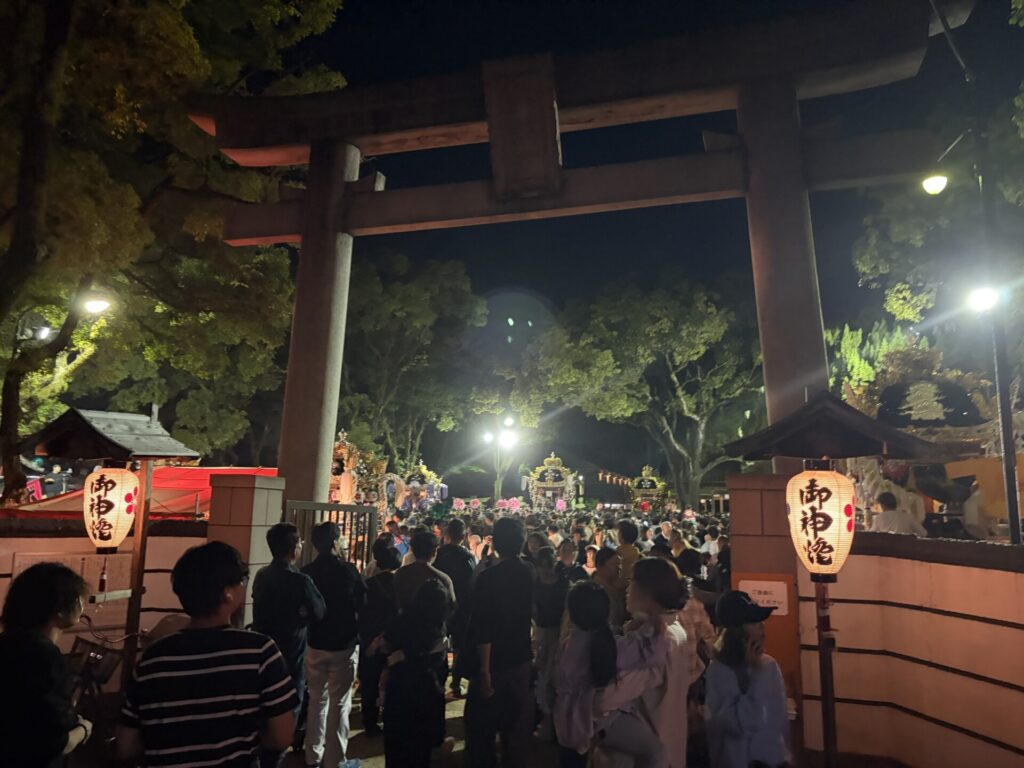 提灯が灯る夜の大鳥居と群衆