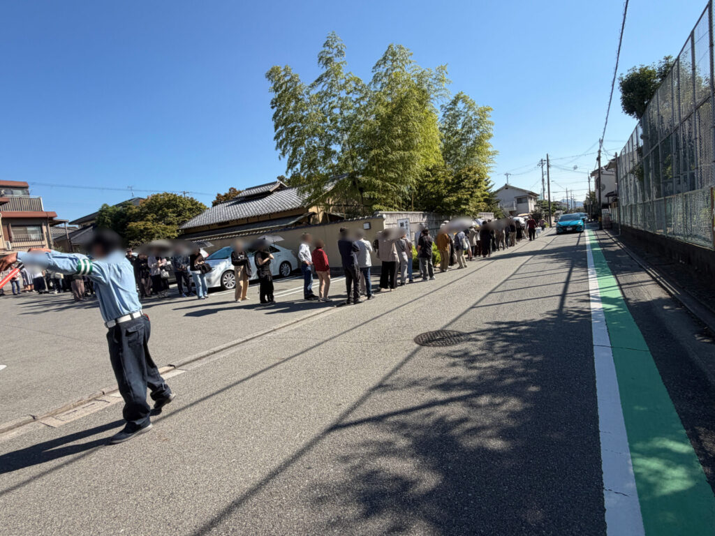 誘導棒を持つ警備員さんと駐車場のほうへ続く行列