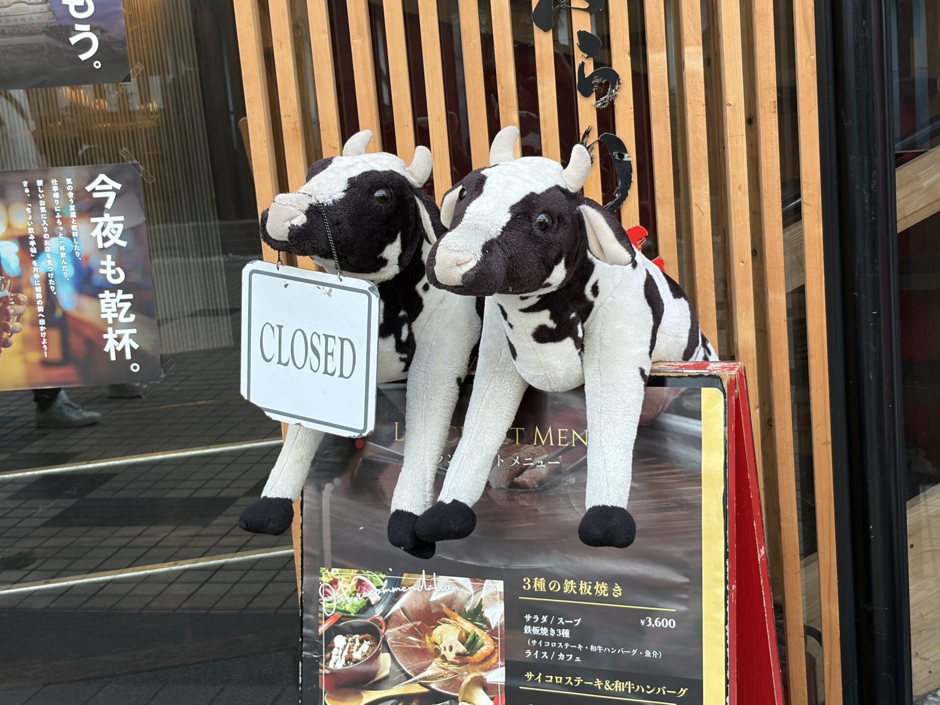 店舗入口の牛のぬいぐるみとCLOSED看板