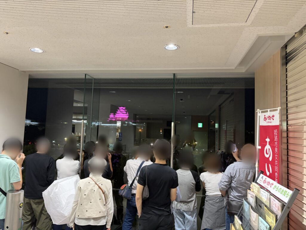 ガラス越しに並んで見守る人たち